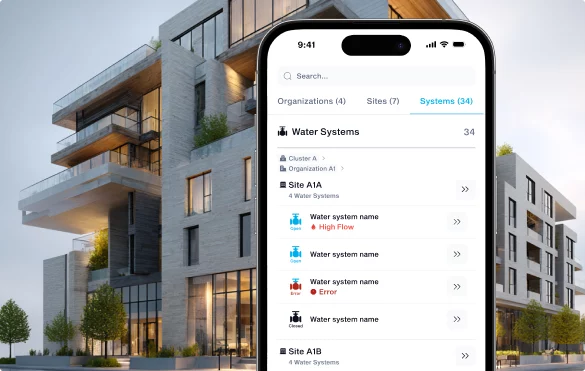 Phone with details about water systems held in front of a large building.